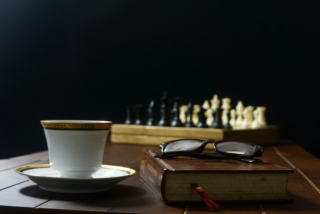 Open mystery novel with reading glasses and a cup of coffee on a wooden table