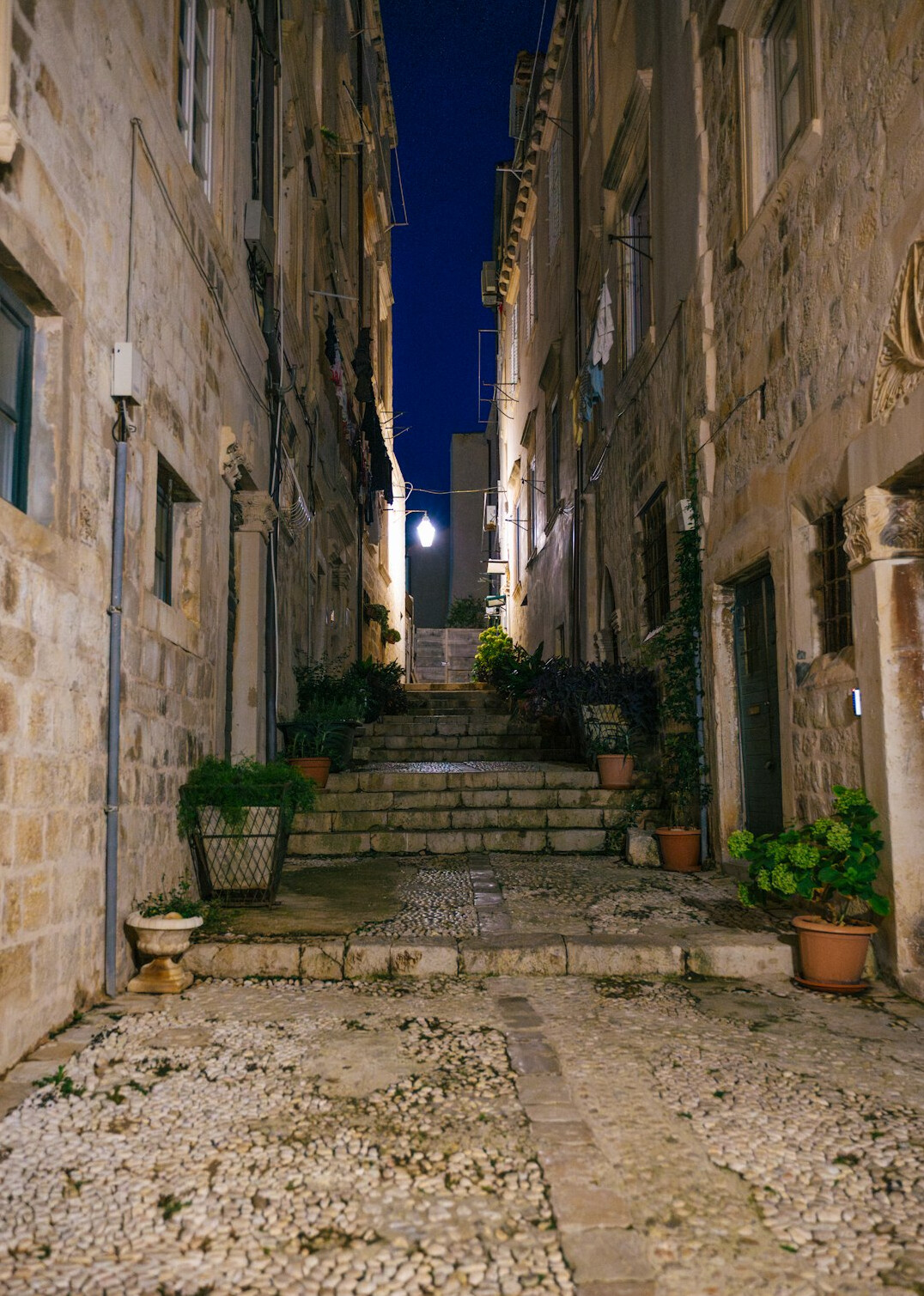 Rainy cobblestone street in the old town of Montevideo at night with warm streetlights